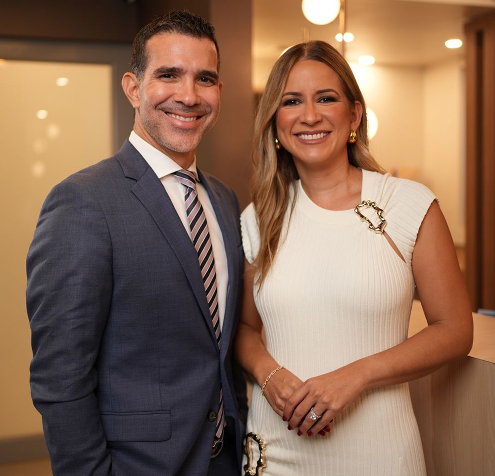 Two smiling professionals posing together indoors.