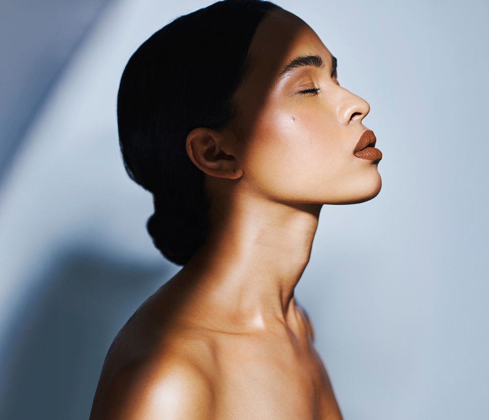 Profile of a woman with bronzed skin.