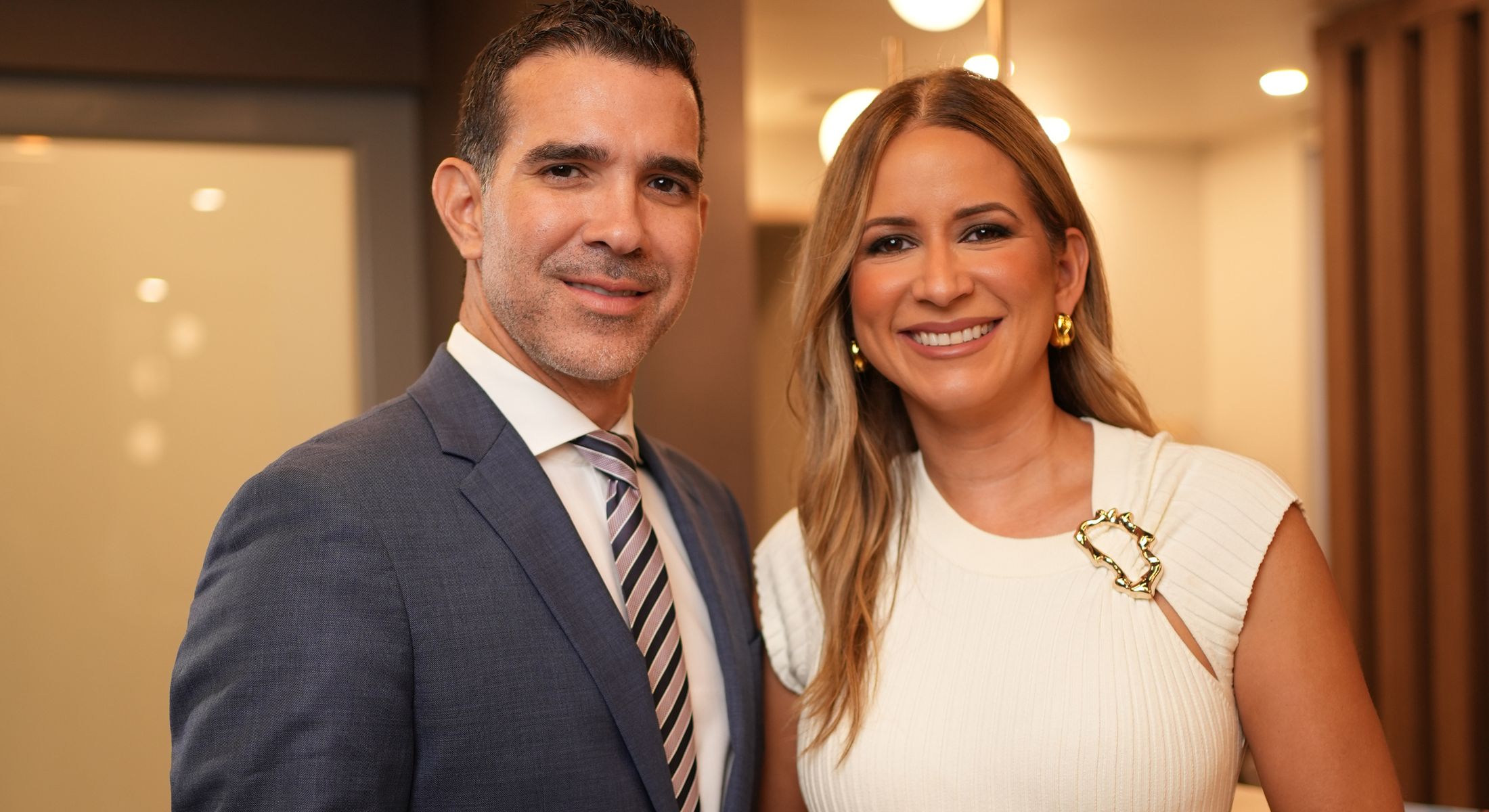 Smiling couple posing together in elegant setting.